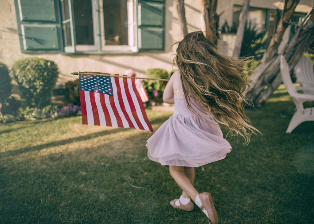 patriotic girl holding american flag for memorial day activities