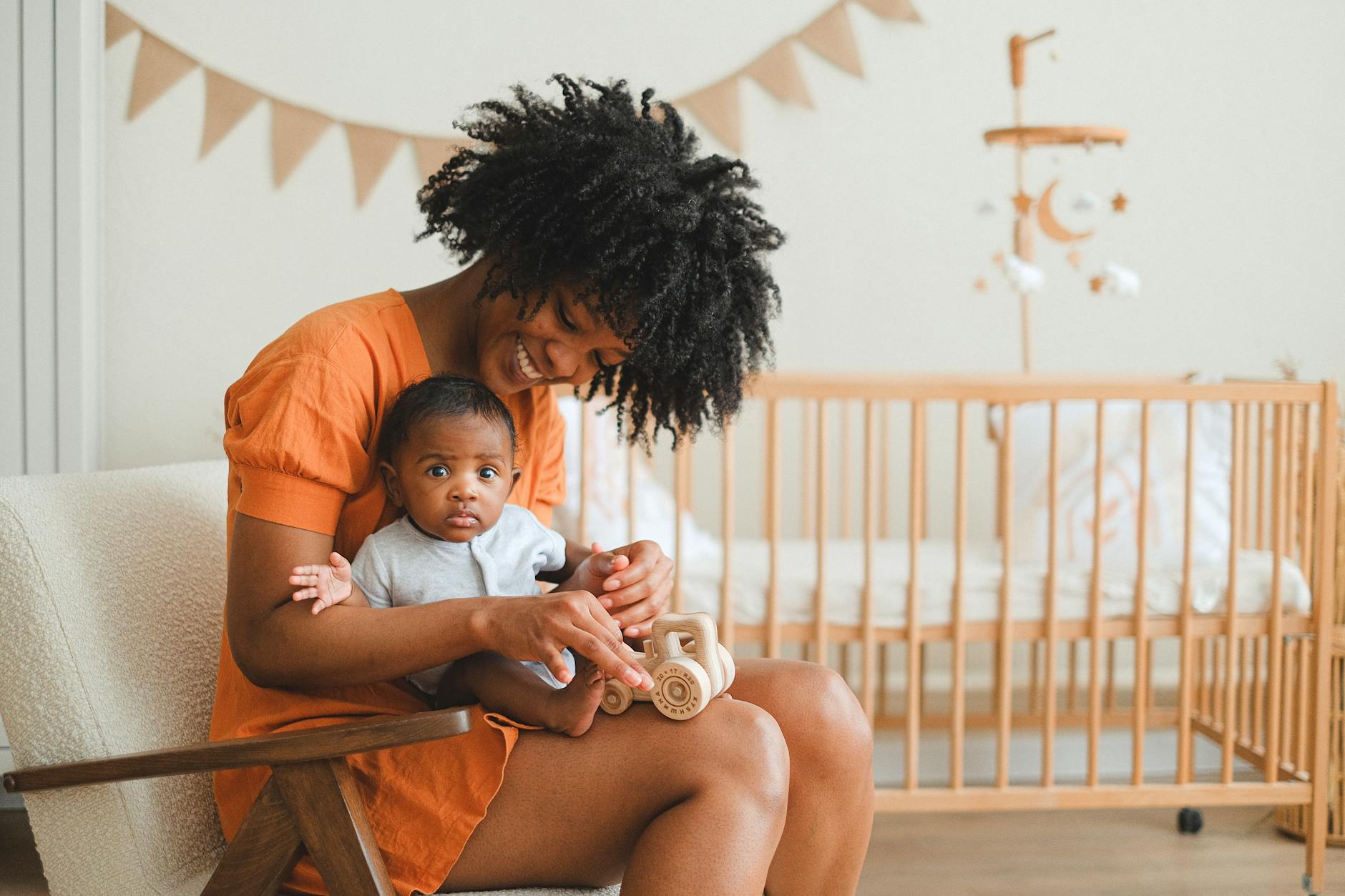 mother holds baby in her lap in a nursery