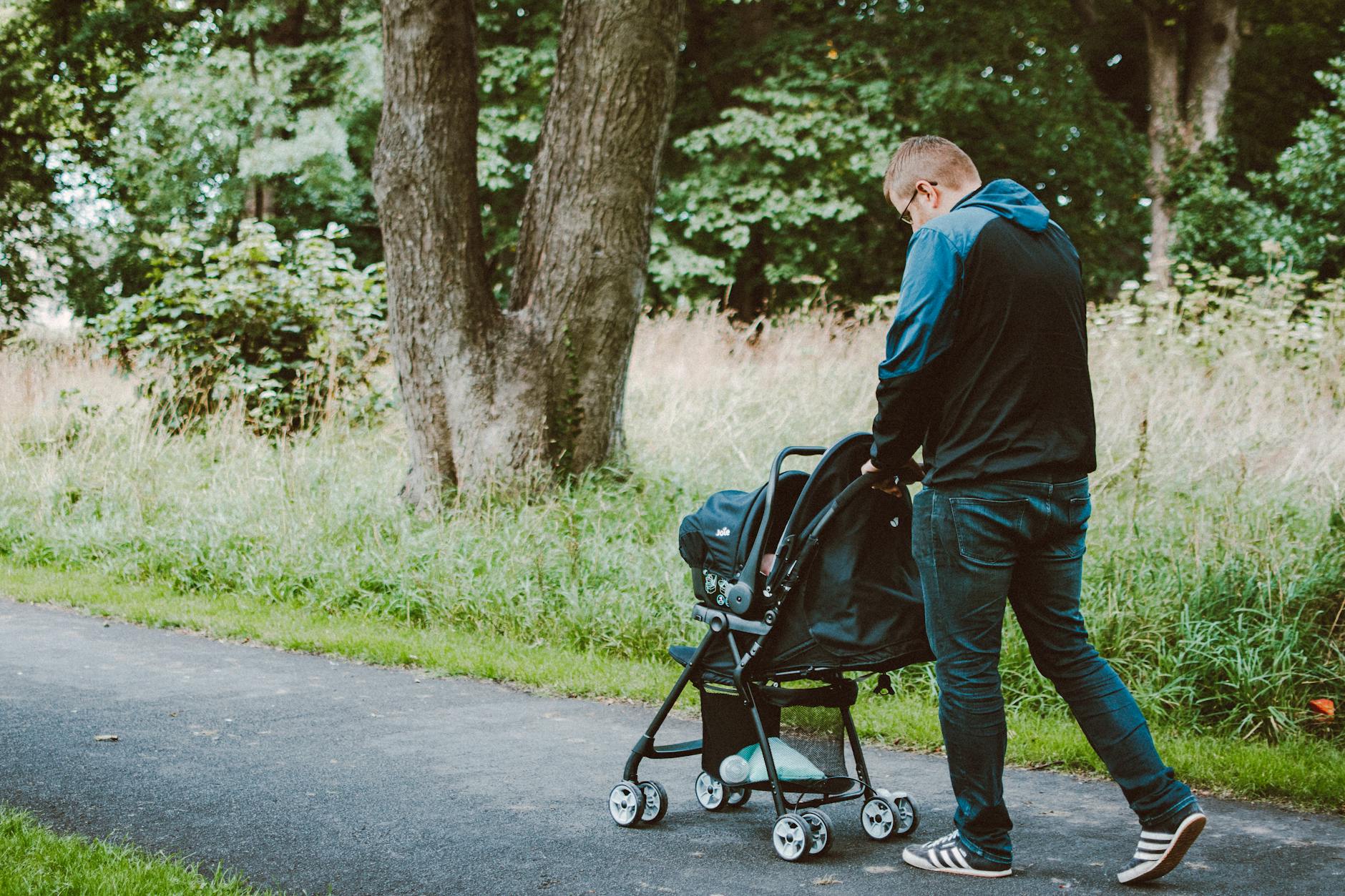 father walking a baby in a stroller