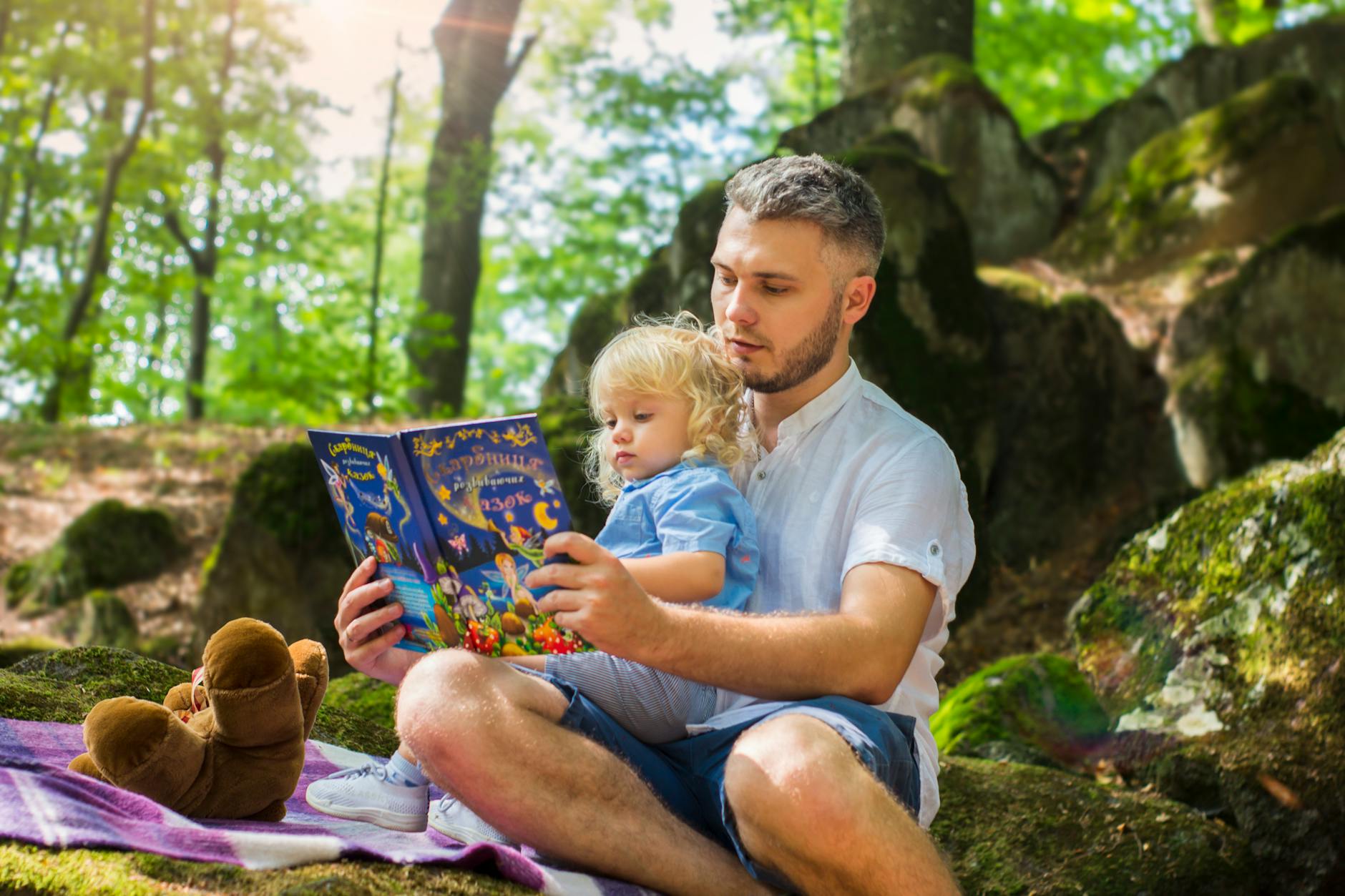 dad reading to daughter in the woods