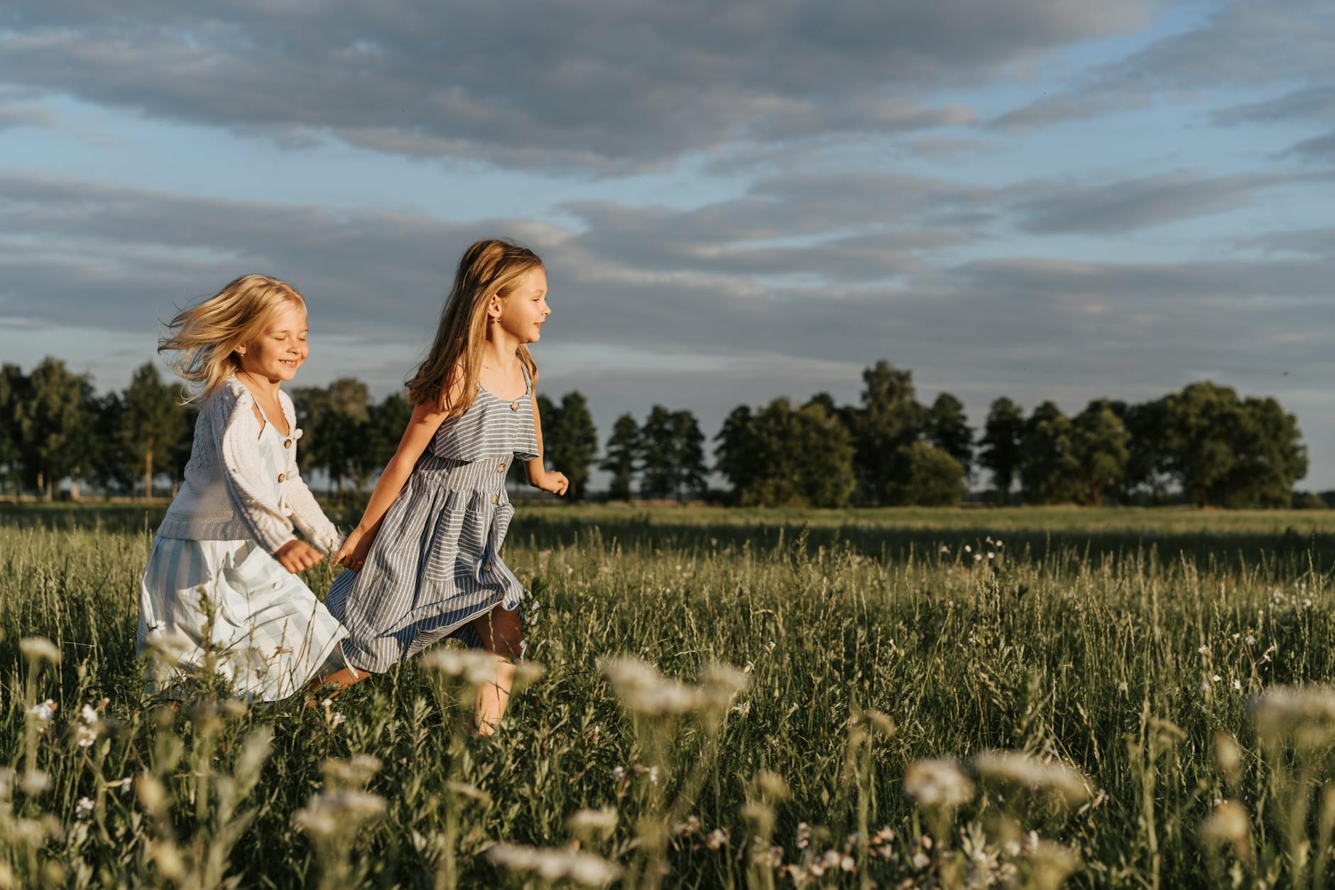 two girls running and holding hands
